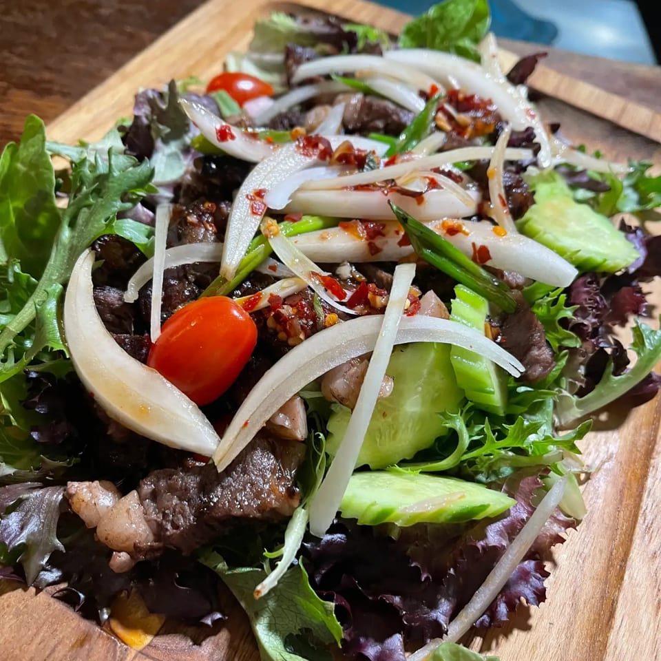 Jintana Thai Farmhouse's spicy beef salad with mixed greens, onions, cucumbers, and cherry tomatoes.